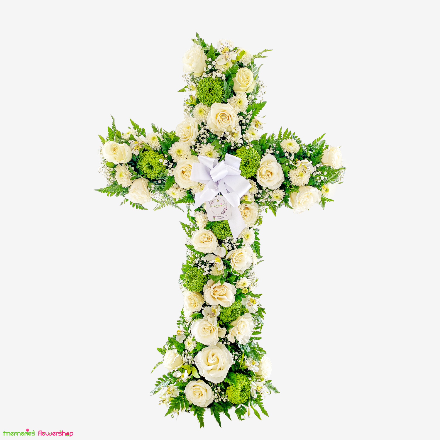 Solemne cruz floral compuesta por rosas ecuatorianas blancas, crisantemos verdes y follajes, perfecta para honrar y recordar. Cruz floral con rosas ecuatorianas blancas, crisantemos verdes, centro verde y follajes