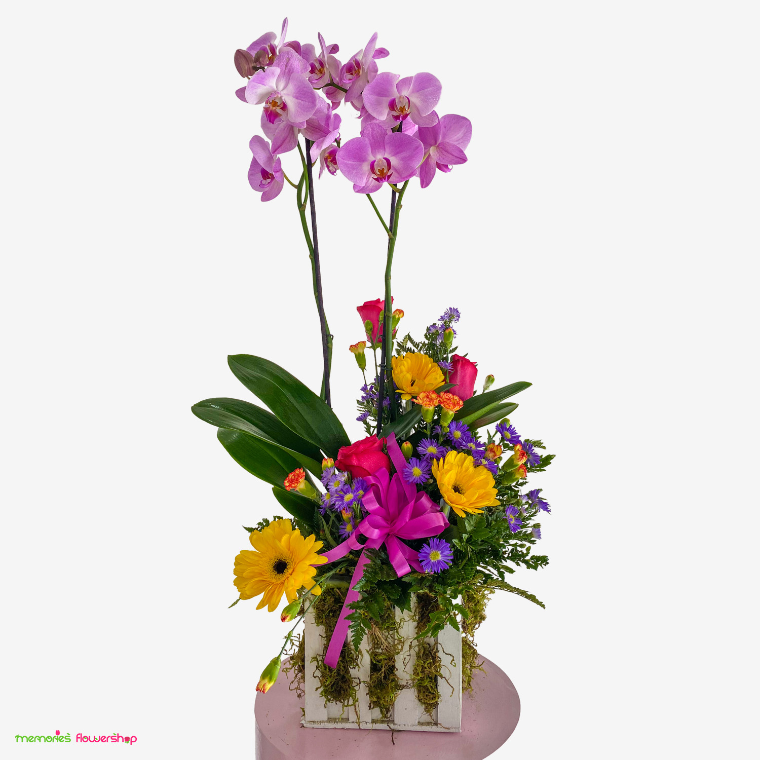 Orquídea de doble vara adornada con rosas y gerberas, ideal para cumpleaños. Orquídea de doble vara con rosas fucsia, gerberas amarillas, montecasino morado, mini clavel y follajes en caja de madera.