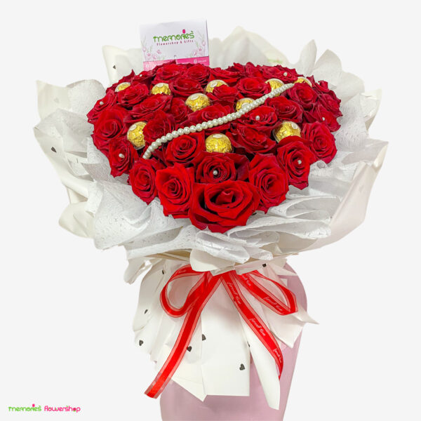 Vista superior del Ramillete Pasión: 40 rosas rojas de Ecuador en forma de corazón, 10 chocolates Ferrero, adornado con cristales y perlas falsas, sobre base decorada con papel coreano.